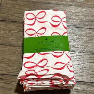 Kate Spade New York "All Wrapped Up" napkins featuring a red bow pattern.